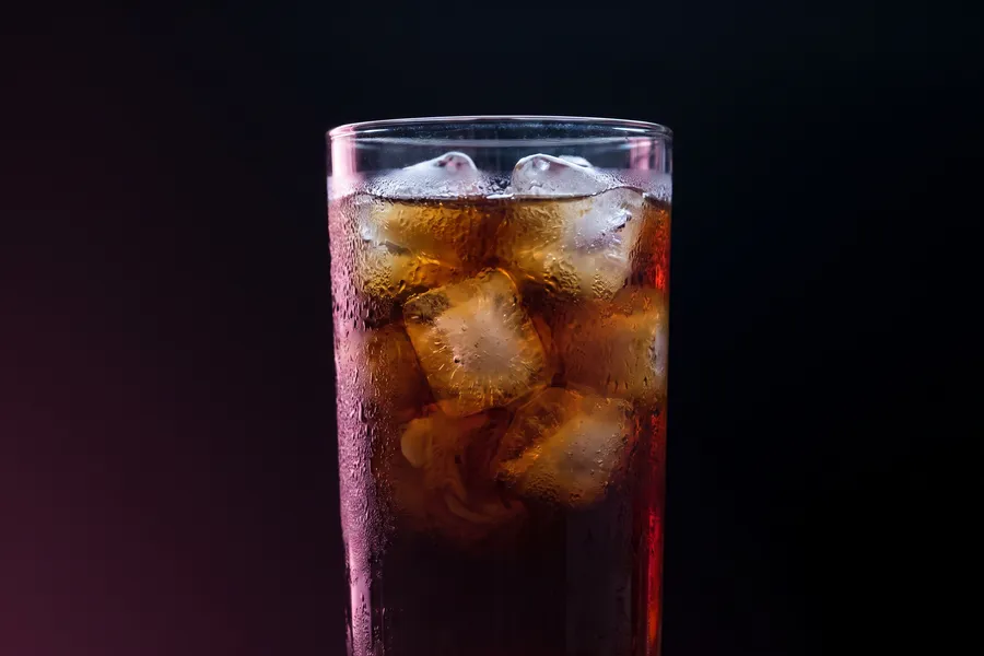 Vaso alto de cold brew sobre hielos grandes, con condensación en el cristal.